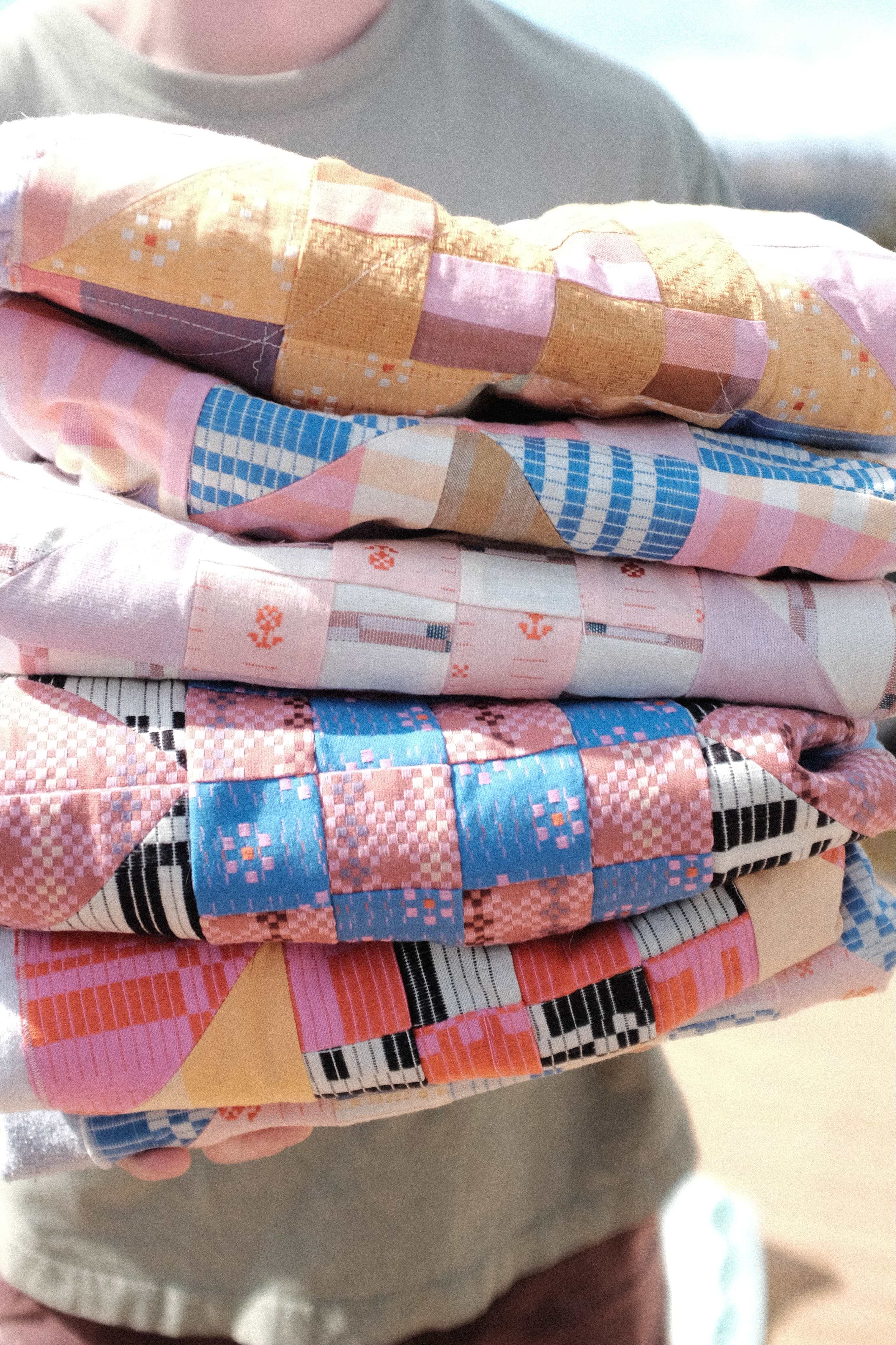Stack of sweatshirts with various quilted patterns on their fronts
